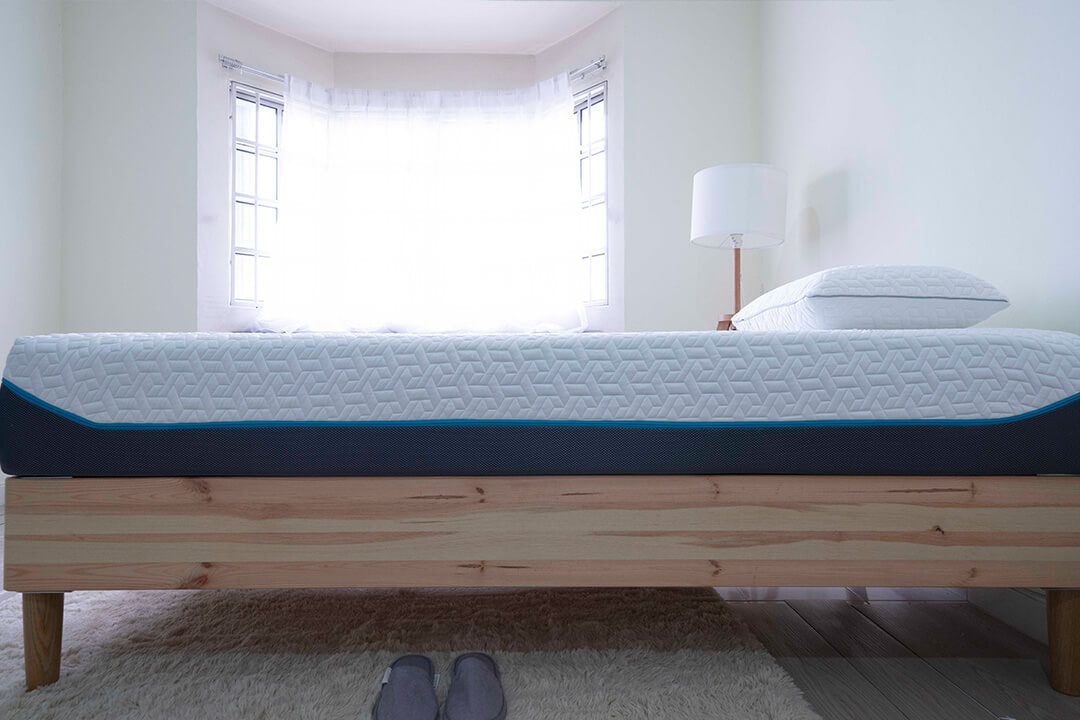 Side view of the Amazeam mattress on a Scandinavian-style IKEA bed frame, featuring a cool-touch quilted cover and a minimalist design, in a bright room with a white fluffy rug on the floor